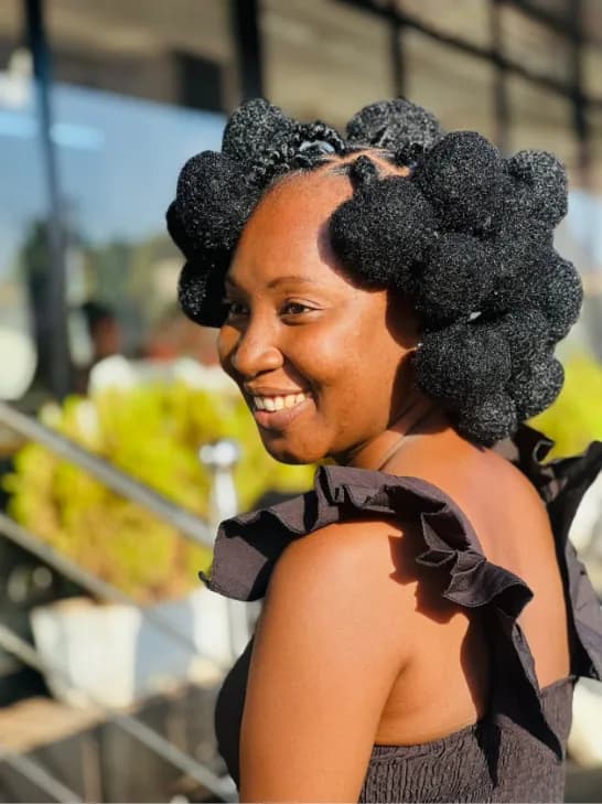 Coiffure en nœuds bantous, cliente souriante